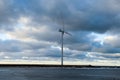 Cloudy blue sky with large wind mill and open water Royalty Free Stock Photo