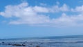 cloudy blue sky over a beautiful stretch of rocky beach