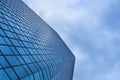 cloudy blue sky reflection skyscraper glass exterior trees framing Royalty Free Stock Photo