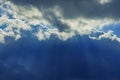 Cloudy dark blue sky stormy background scenic view with sun rays through clouds dramatic wallpaper picture Royalty Free Stock Photo