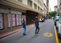 Cloudy day in Cape Town. Man and woman in face masks walking down side road. Royalty Free Stock Photo