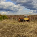 Cloudy day in early spring. Abandoned broken-down tractor. Russia.