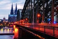 Cloudy day view of Cathedral and illuminated Hohenzollern bridge in Cologne, Germany Royalty Free Stock Photo