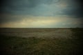 Cloudy evening sky over a plowed farm field. Landscape. Vignette Royalty Free Stock Photo