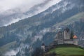 Cloudy and foggy autumn alpine mountain slopes scene. Austrian Lienzer Dolomiten Alps and Heinfels castle, Sillian, Austria