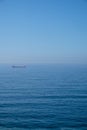 Cloudy horizon and Fog over the sea waves, natural background, red cargo ship on the horizon Royalty Free Stock Photo