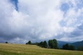 Cloudy landscape in countryside. Green field and blue sky with big clouds.