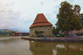 Cloudy landscape of Drava River in Maribor. The ancient Water Tower and Old Bridge at the background. Vibrant cloudy sky. Royalty Free Stock Photo