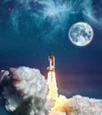 Cloudy launch of rocket Space Shuttle into colorful starry outer space and the full moon. `The elements of this image