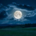 Cloudy night sky with full moon in a serene landscape