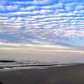 Sandy beach ocean shore coast slur sky white clouds Royalty Free Stock Photo