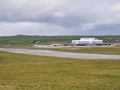 On a cloudy, overcast day, a helicopter lands at Sumburgh Airport in the south of Shetland in the UK
