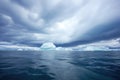 cloudy polar sky over iceberg-strewn water, seen from ship