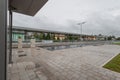 Cloudy and rainy view of freshly renovated Domzale train station with empty platforms and puddles of water around