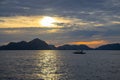 Cloudy seaside landscape with distant mountains and boat. Romantic evening seascape with sunset Royalty Free Stock Photo