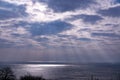 Cloudy sky above the sea and sun rays pass through the clouds Royalty Free Stock Photo