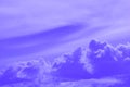 Cloudy sky background image in purple hues, with cumulus clouds