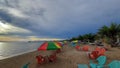 Cloudy sky beach with plastic chair and umbrella Royalty Free Stock Photo