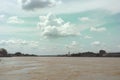Cloudy Sky over Muddy River with Golden Buddha Statue Royalty Free Stock Photo
