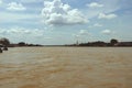 Cloudy Sky over Muddy River with Golden Buddha Statue Royalty Free Stock Photo