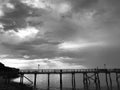 a cloudy sky over the water near a bridge and beach Royalty Free Stock Photo