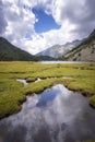 The cloudy sky reflected in a pond near a lake in a mountain landscape in the Pyrenees of Lleida, Estany Llong, Aiguestortes, Royalty Free Stock Photo