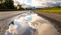 Cloudy Sky Reflection in a Rural Road Puddle Royalty Free Stock Photo
