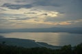 Cloudy sky with a scenic sunset over a lake and forests Royalty Free Stock Photo