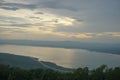 Cloudy sky with scenic sunset over a lake and forests Royalty Free Stock Photo