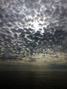 Cloudy sky and sun rays over sea with a boat