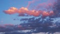 Cloudy sky at sunset. Blue and pink natural background or wallpaper. Evening sun effectively illuminates the clouds in yellow. Royalty Free Stock Photo