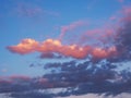 Cloudy sky at sunset. Blue and pink natural background or wallpaper. Setting sun effectively illuminates the clouds in yellow. Royalty Free Stock Photo