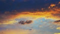 Cloudy sky at sunset. Dark blue and yellow natural background or wallpaper. The rays of the setting sun effectively illuminate the Royalty Free Stock Photo