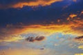 Cloudy sky at sunset. Dark blue and yellow natural background or wallpaper. The rays of the setting sun effectively illuminate the Royalty Free Stock Photo