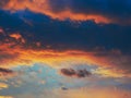 Cloudy sky at sunset. Dark blue and yellow natural background or wallpaper. The rays of the setting sun effectively illuminate the Royalty Free Stock Photo