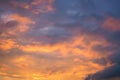 Cloudy sky at sunset. Dark purple and yellow natural background or wallpaper. The rays of the setting sun effectively illuminate Royalty Free Stock Photo