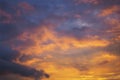 Cloudy sky at sunset. Dark purple and yellow natural background or wallpaper. The rays of the setting sun effectively illuminate Royalty Free Stock Photo