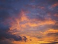 Cloudy sky at sunset. Dark purple-yellow natural background or wallpaper. The rays of the setting sun effectively illuminate the Royalty Free Stock Photo