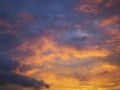 Cloudy sky at sunset. Dark purple-yellow natural background or wallpaper. The rays of the setting sun effectively illuminate the Royalty Free Stock Photo
