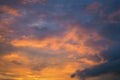 Cloudy sky at sunset. Dark violet and yellow natural background or wallpaper. The rays of the setting sun effectively illuminate Royalty Free Stock Photo