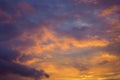 Cloudy sky at sunset. Dark violet-yellow natural background or wallpaper. The rays of the setting sun effectively illuminate the Royalty Free Stock Photo
