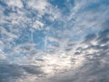 Cloudy sky, white clouds on a blue sky. Jet military plane flies through clouds in a blue sky