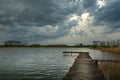 Cloudy stormy sky over a lake with a pier Royalty Free Stock Photo