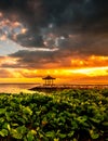 Sunrise with green plants in the foreground and a Balinese pavilion? Sanur, Bali