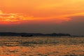 Cloudy sunset with silhouette of lonely boat Royalty Free Stock Photo