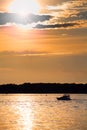 Cloudy sunset with silhouette of lonely boat Royalty Free Stock Photo