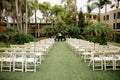Cloudy tropical wedding venue - ceremony set up with white wooden trees, palm trees and vintage lanterns
