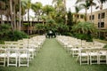 Cloudy tropical wedding venue - ceremony set up with white wooden trees, palm trees and vintage lanterns