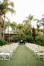 Cloudy tropical wedding venue - ceremony set up with white wooden trees, palm trees and vintage lanterns