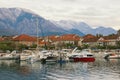 Cloudy winter day. Small marina for fishing boats at foot of mountains. Montenegro, Tivat city